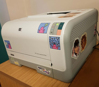 A photo of the printer, with a handful of stickers on it.